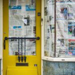 Leerstehende Gebäude 2026, gelbe Tür mit Zeitungspapier, beschädigtes Fenster